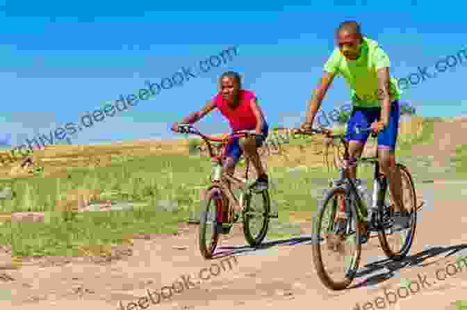 Cyclists Riding Through A Village In Africa The Lions On The Road: Cycling London To Cape Town For Save The Children Fund